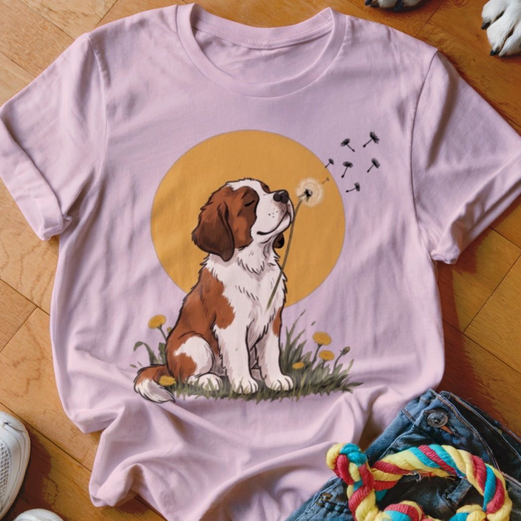 Light pink t-shirt featuring an illustration of a puppy blowing dandelion seeds against a yellow circle.