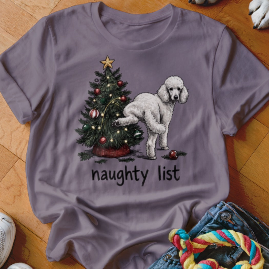 Poodle with leg raised by Christmas tree with text "naughty list".