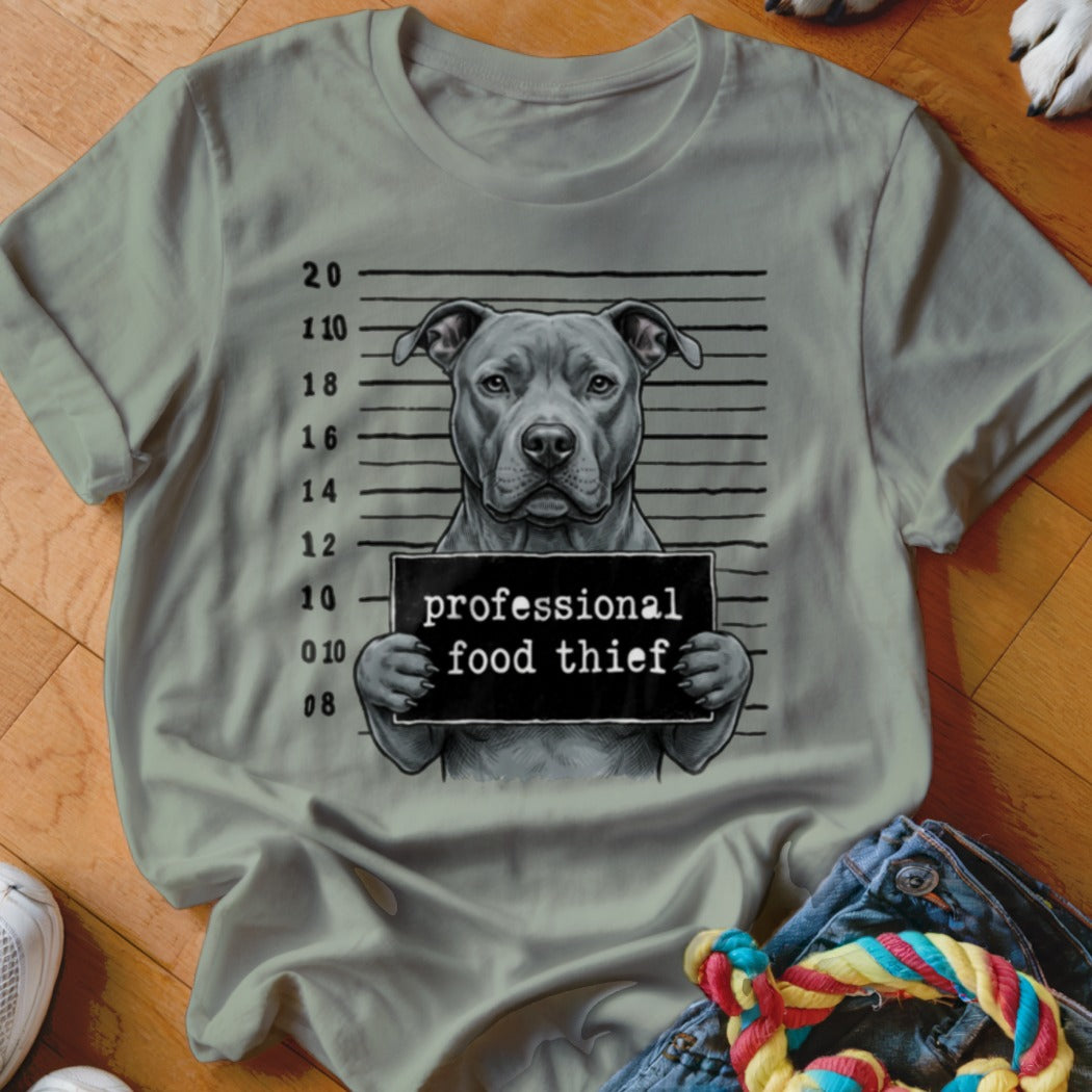 Pitbull dog with mugshot sign that says "professional food thief"