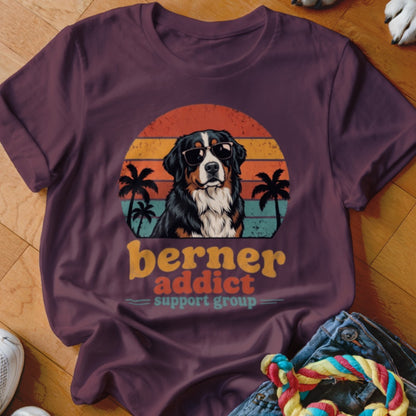 A purple t-shirt featuring a retro sunset graphic, a Bernese Mountain Dog wearing sunglasses, and palm trees.