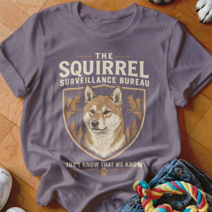 Mauve t-shirt featuring a Shiba Inu graphic and the text "The Squirrel Surveillance Bureau, They Know That We Know."