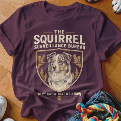 Maroon t-shirt featuring an Australian Shepherd graphic with the text The Squirrel Surveillance Bureau.