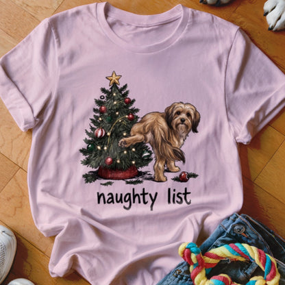Pink t-shirt with a dog near a Christmas tree and the text "naughty list."