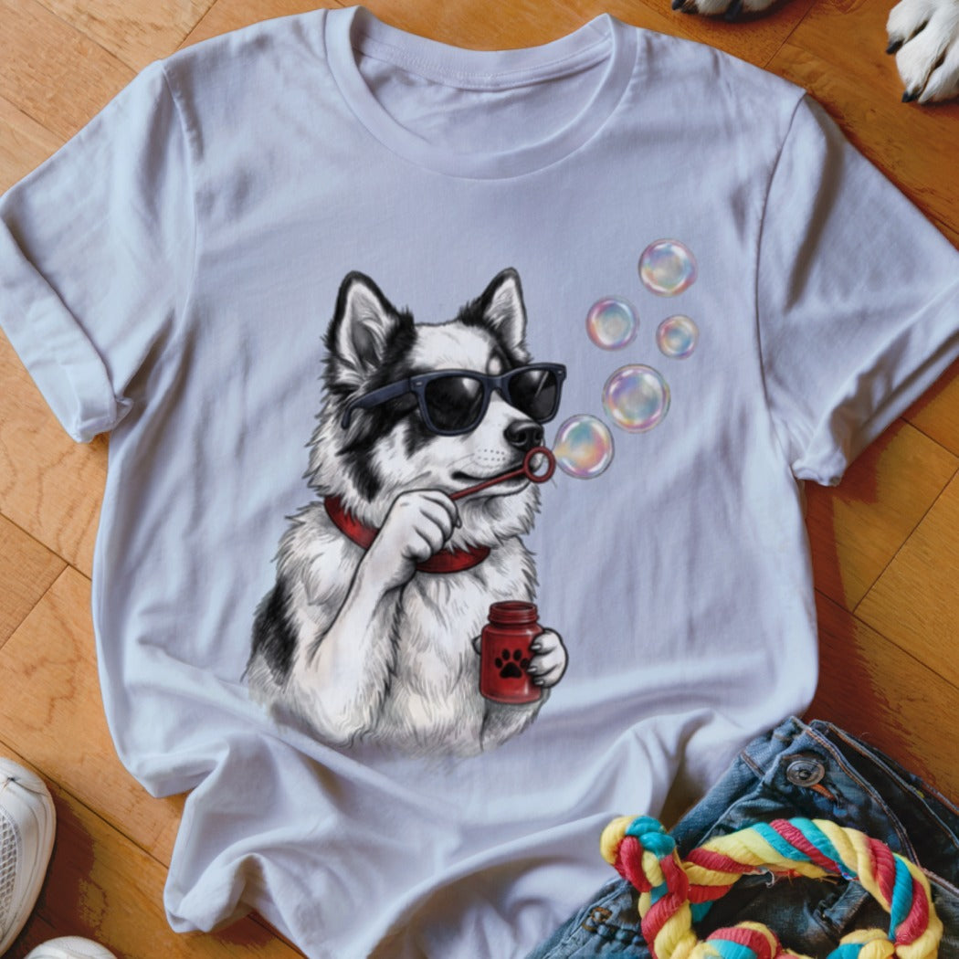 A white crewneck t-shirt featuring a graphic of a black and white dog wearing sunglasses and blowing bubbles.