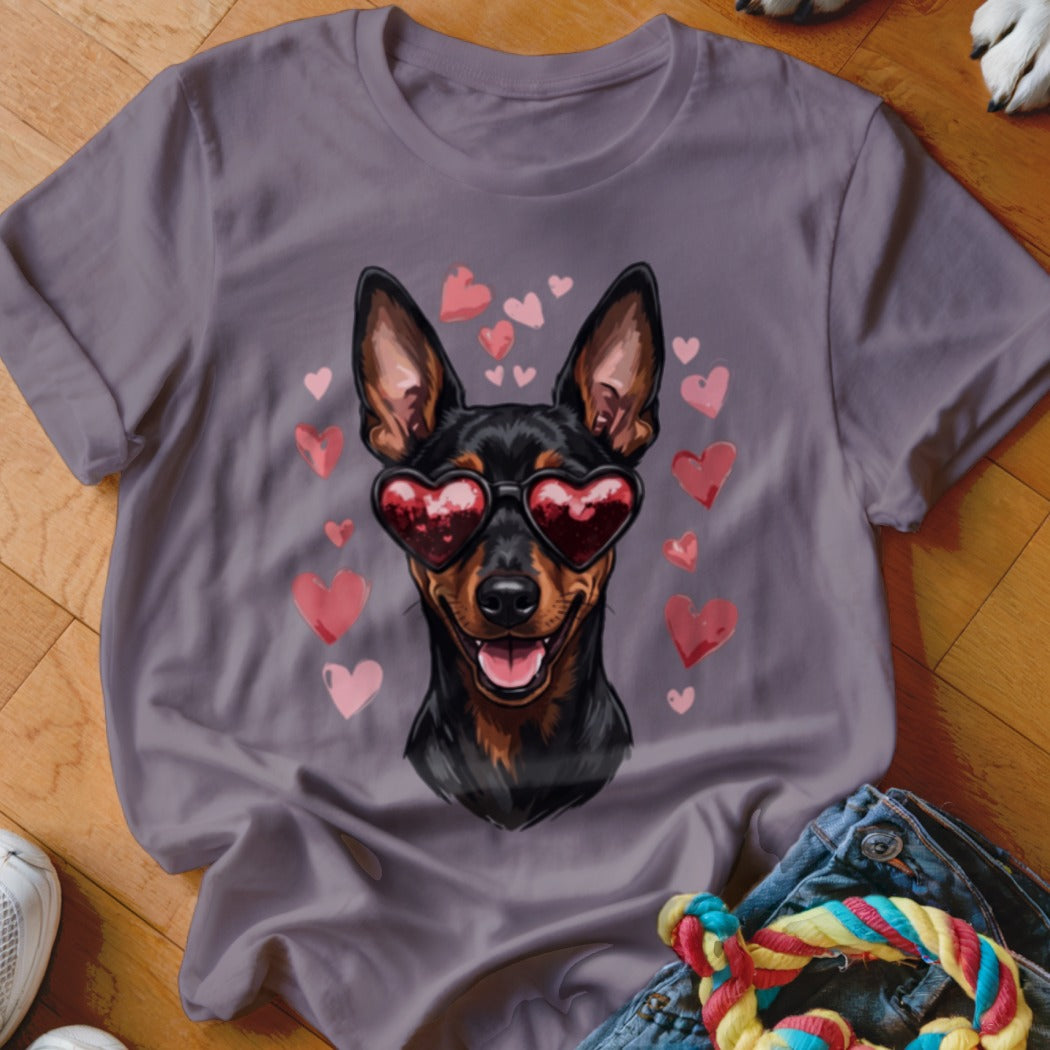 A purple t-shirt featuring a graphic of a black and tan dog wearing heart-shaped sunglasses, surrounded by pink hearts.