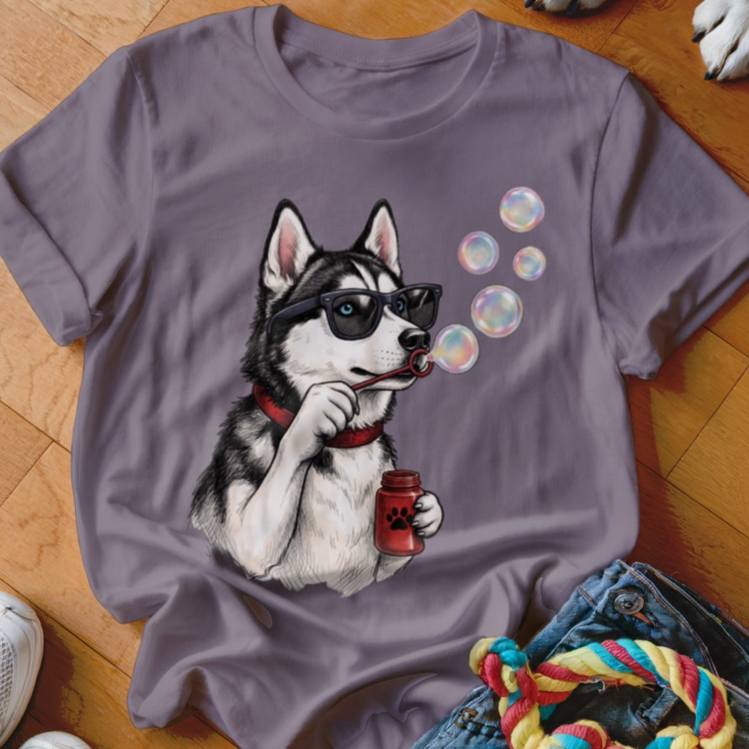 A purple crewneck t-shirt features a graphic of a husky wearing sunglasses and blowing soap bubbles.