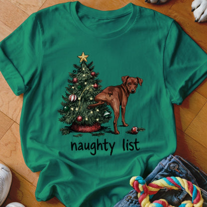 Green t-shirt with dog by Christmas tree and text "naughty list"