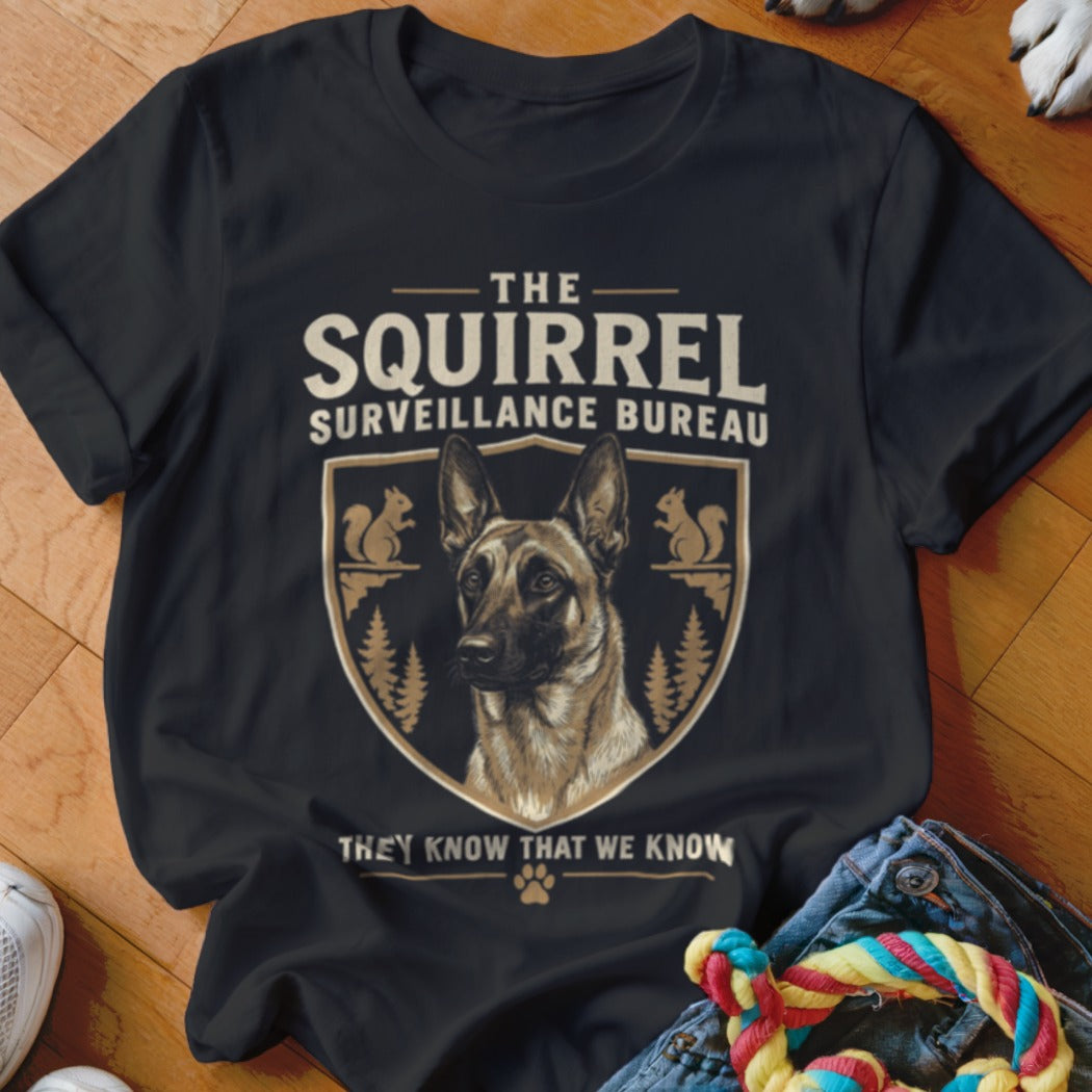 Black t-shirt featuring a graphic of a German Shepherd inside a crest with squirrels and the text The Squirrel Surveillance Bureau.