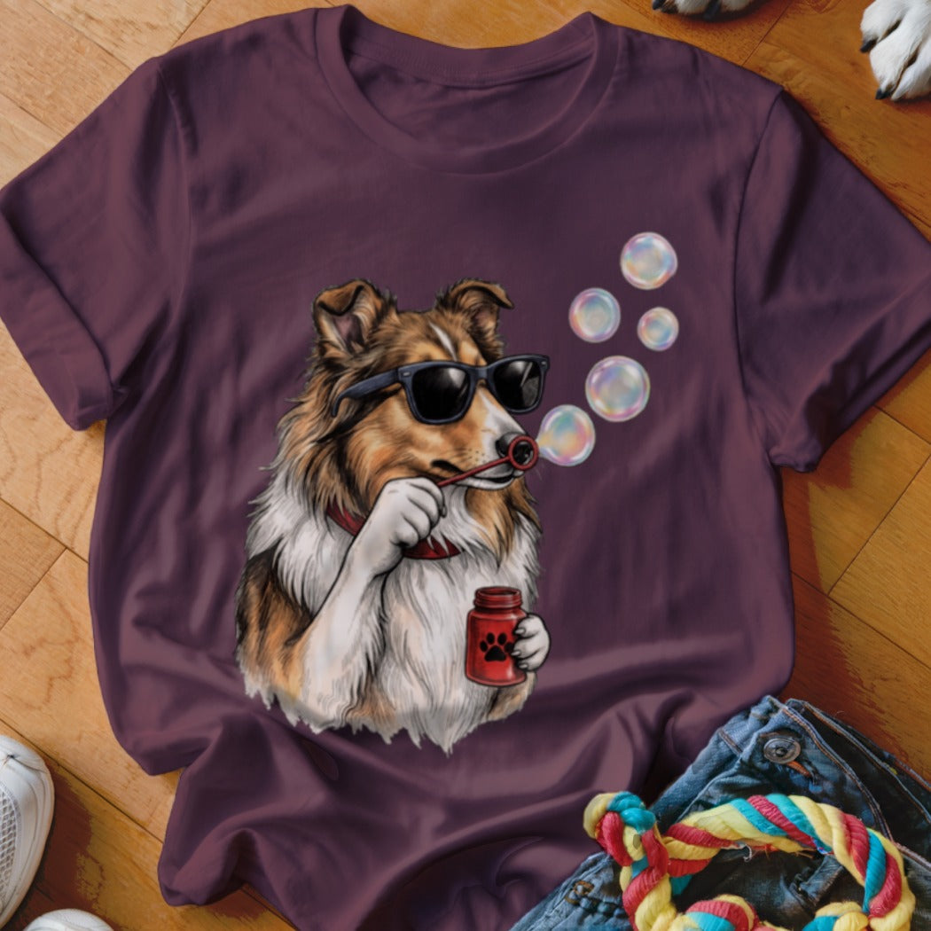 A dark purple t-shirt featuring an illustration of a dog wearing sunglasses and blowing bubbles.