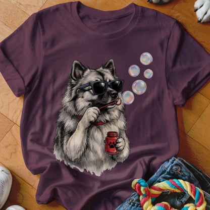 A dark purple crewneck t-shirt featuring a graphic of a fluffy dog wearing sunglasses and blowing bubbles.