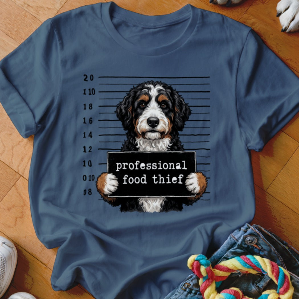 Bernese Mountain Dog mugshot with "professional food thief" sign.