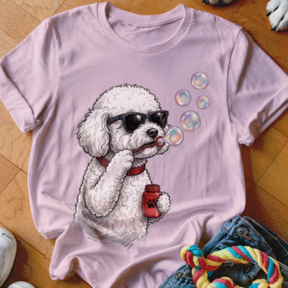 A light pink t-shirt featuring a graphic of a white poodle wearing sunglasses and blowing bubbles.