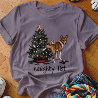 A grey t-shirt featuring a Basenji dog peeing on a Christmas tree with the text "naughty list".