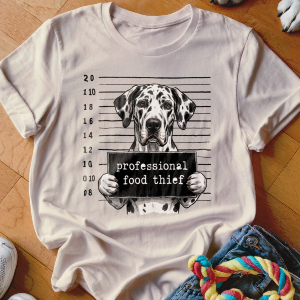 Dalmatian dog mugshot with "professional food thief" sign on a t-shirt.
