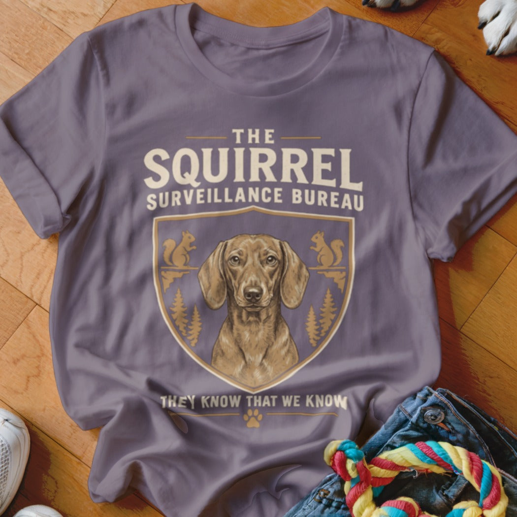 Purple t-shirt featuring a dachshund graphic with text reading The Squirrel Surveillance Bureau.