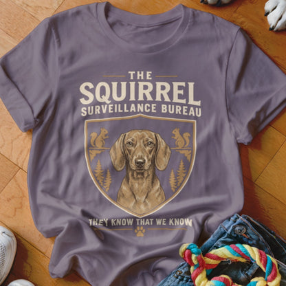 Purple t-shirt featuring a dachshund graphic with text reading The Squirrel Surveillance Bureau.