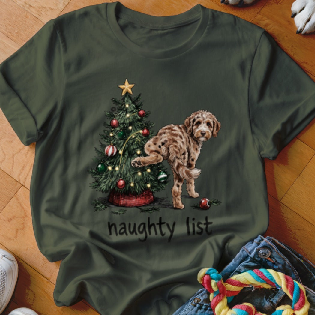 Dog lifting leg on Christmas tree, text "naughty list".