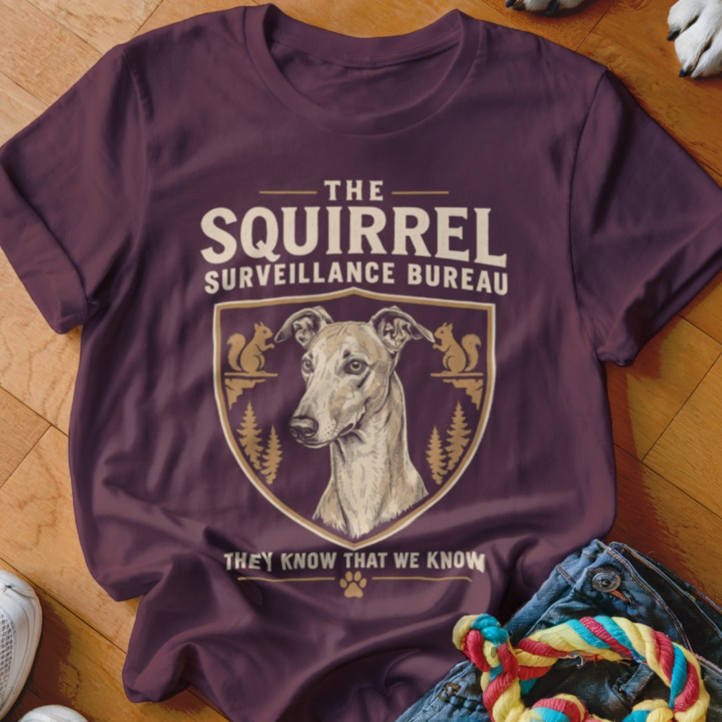A dark plum crewneck t-shirt featuring a graphic of an Italian Greyhound inside a crest labeled The Squirrel Surveillance Bureau.