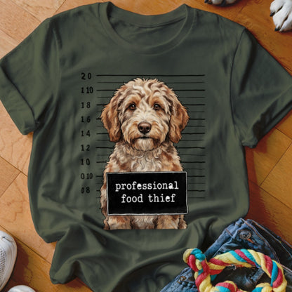 Dog mugshot with "professional food thief" sign on a green t-shirt.