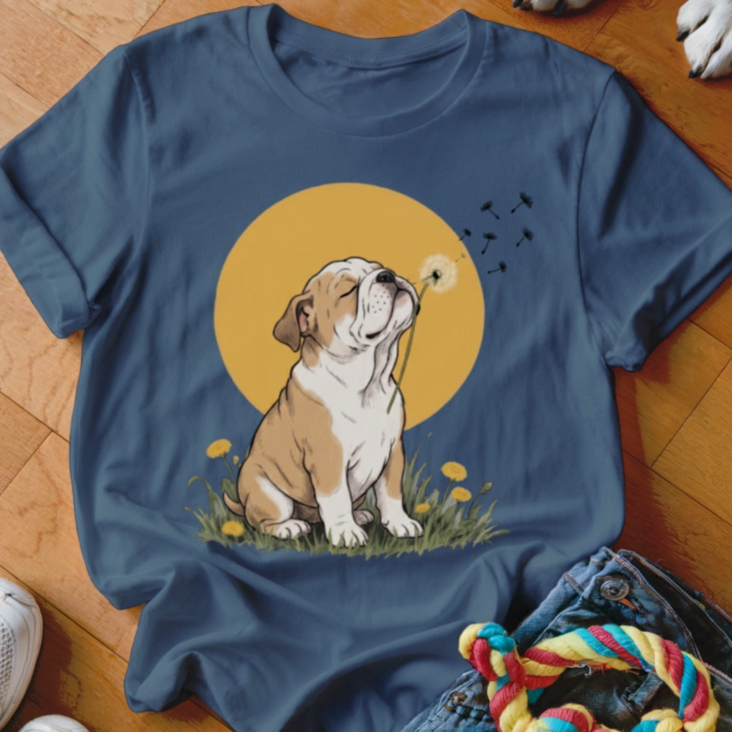 Dark blue short-sleeve t-shirt featuring a graphic of a bulldog blowing dandelion seeds against a yellow sun.