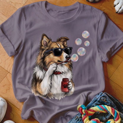 A grey t-shirt featuring an illustration of a dog wearing sunglasses and blowing bubbles.
