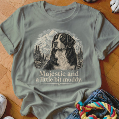 T-shirt with a vintage-style print of a Bernese Mountain Dog with mountains and trees, reads "Majestic and a little bit muddy."