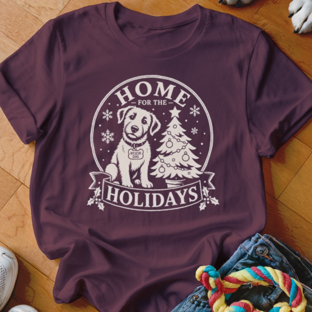 Maroon t-shirt with white graphic of a rescue dog, Christmas tree, and text "Home for the Holidays".
