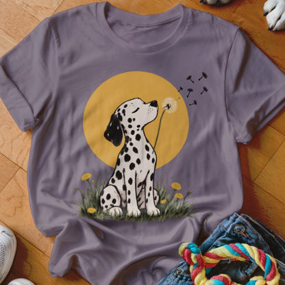 A purple t-shirt featuring an illustration of a Dalmatian blowing dandelion seeds against a yellow circle.