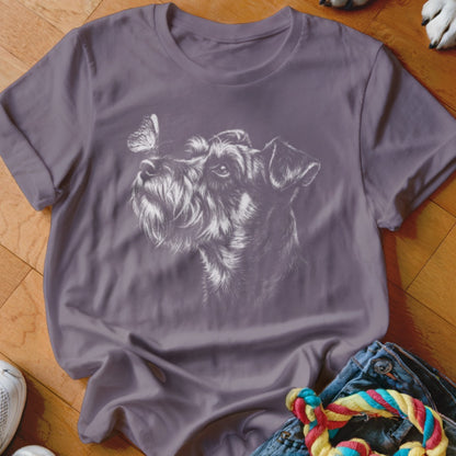 A purple short-sleeved t-shirt featuring a white sketch of a schnauzer dog looking at a butterfly.