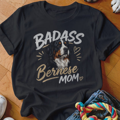 A black t-shirt printed with the text Badass Bernese Mom and a Bernese Mountain Dog illustration.