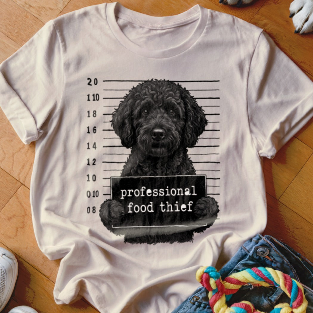 Black dog in mugshot with "professional food thief" sign and height markers.
