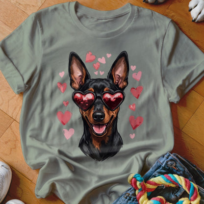 Sage green crewneck t-shirt featuring an illustration of a black and tan dog wearing heart-shaped sunglasses surrounded by pink hearts.