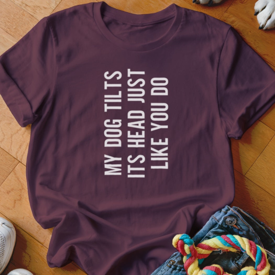 Maroon t-shirt with white text reading "MY DOG TILTS ITS HEAD JUST LIKE YOU DO".