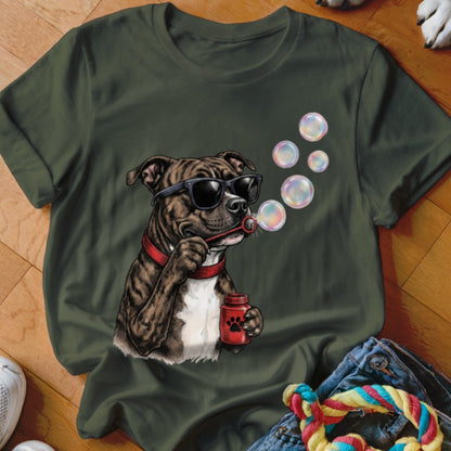 An olive green crewneck t-shirt featuring a graphic of a brindle dog wearing sunglasses and blowing soap bubbles.