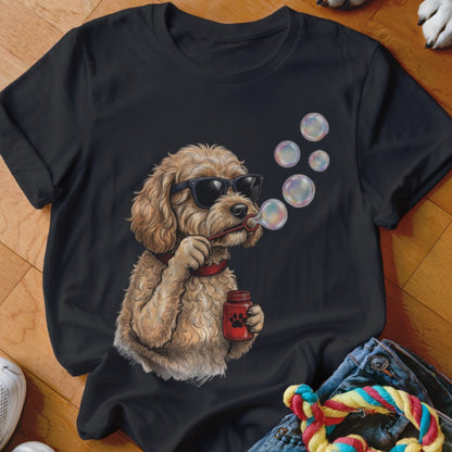 A black t-shirt features an illustration of a fluffy, light brown dog wearing sunglasses and blowing bubbles.