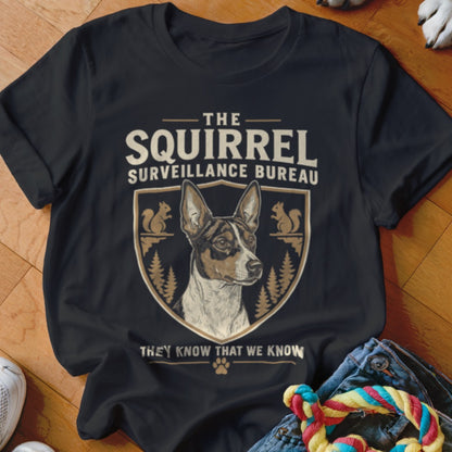 A black t-shirt features a graphic with a dog, squirrels, and the text The Squirrel Surveillance Bureau.
