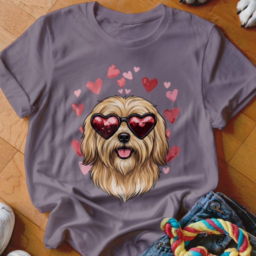 A purple t-shirt featuring a fluffy dog wearing heart-shaped sunglasses surrounded by pink and red hearts.