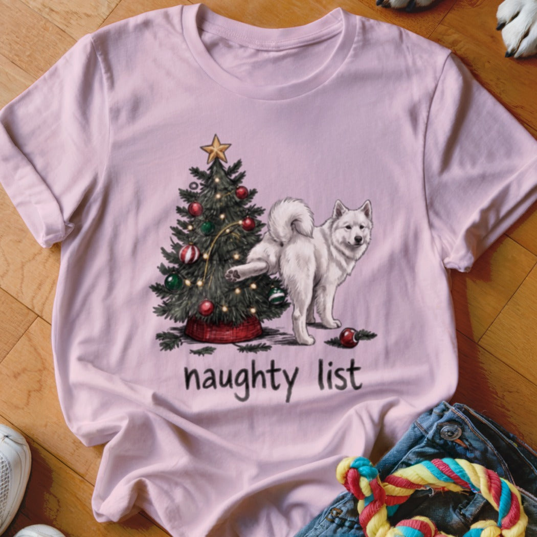 Light pink t-shirt featuring a graphic of a white dog lifting its leg against a Christmas tree.