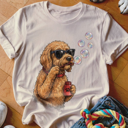 Light pink t-shirt featuring a graphic of a golden doodle wearing sunglasses and blowing bubbles.