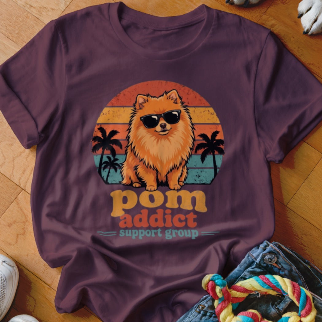 Maroon t-shirt featuring a retro graphic of a Pomeranian dog wearing sunglasses with sunset and palm tree background.