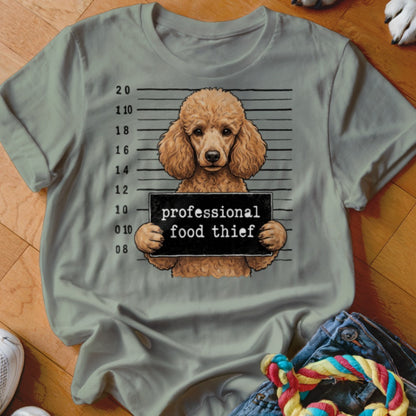 Poodle mugshot with "professional food thief" sign on a light green t-shirt.