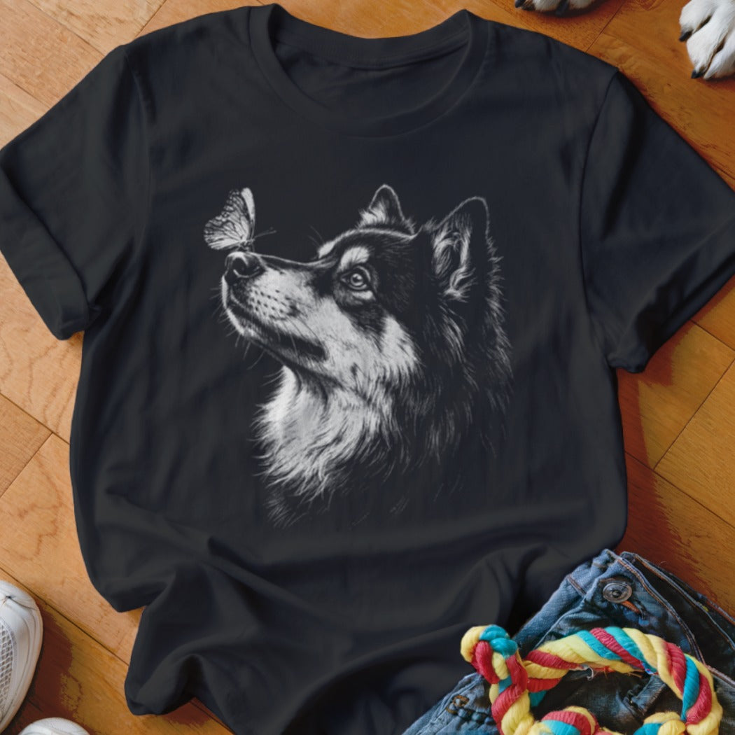Black t-shirt featuring a white graphic of a husky dog looking up at a butterfly on its nose.