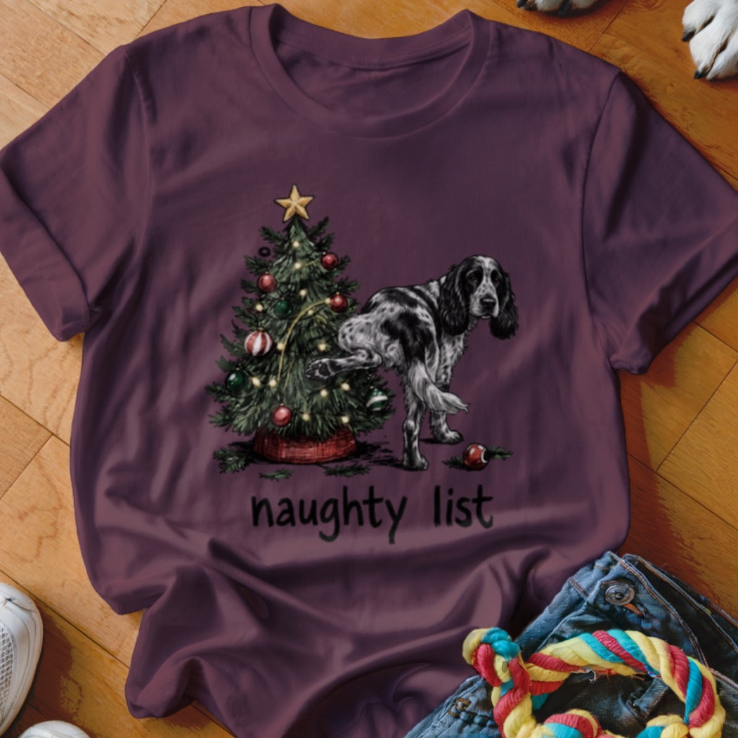 English Setter lifting leg on Christmas tree with "naughty list" text.