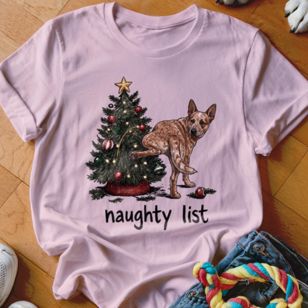 Pink t-shirt with a Christmas tree and dog graphic that reads "naughty list".