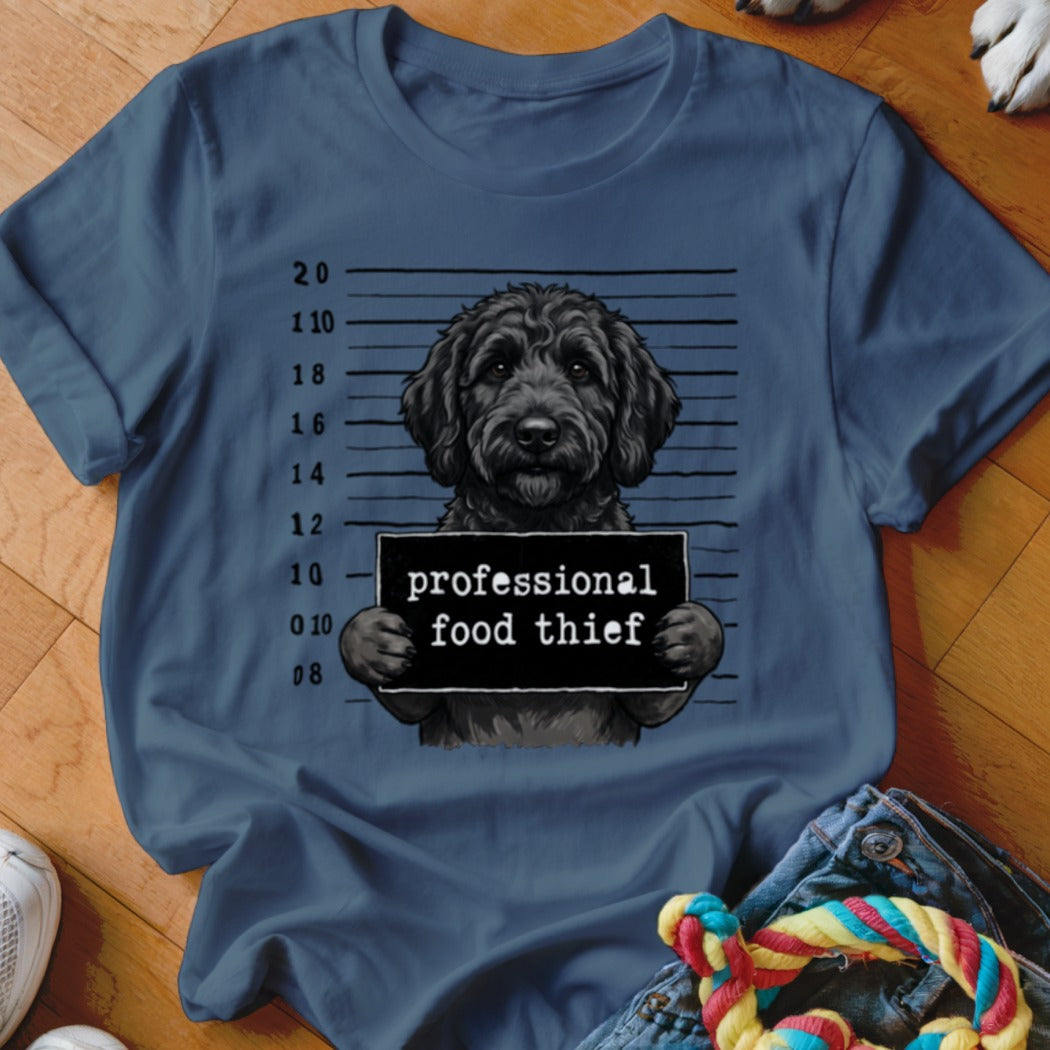 Black doodle dog with mugshot sign reading "professional food thief".