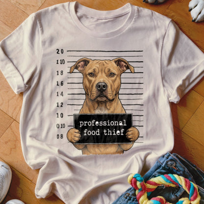 Pit bull mugshot with sign reading "professional food thief" on a t-shirt.