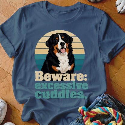 Bernese Mountain Dog wearing a t-shirt that says "Beware: excessive cuddles".