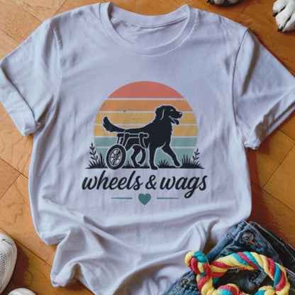 Black dog in a wheelchair graphic with "wheels & wags" text on a white t-shirt.