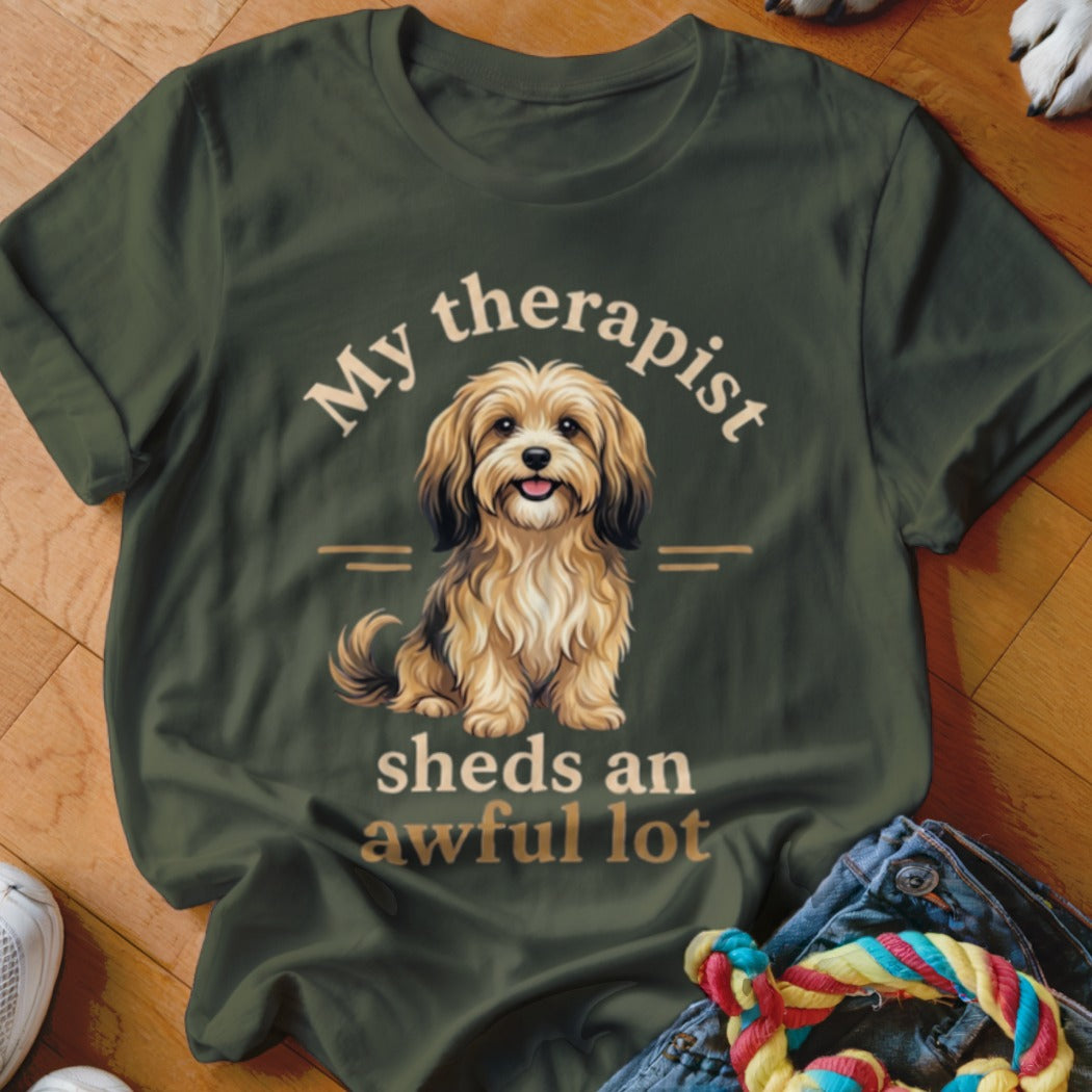 Olive green t-shirt with a drawing of a fluffy dog and text "My therapist sheds an awful lot".