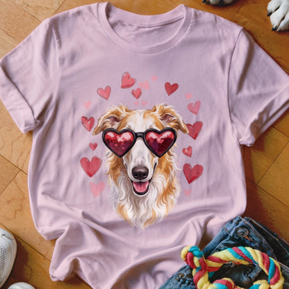 A light pink t-shirt featuring a graphic of a long-haired dog wearing heart-shaped sunglasses surrounded by pink hearts.